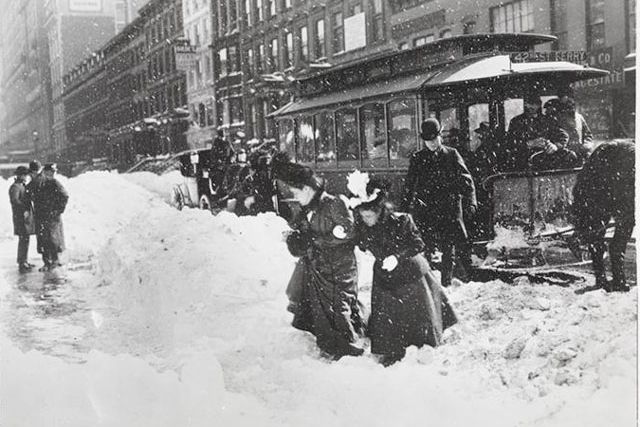 "Looking East on 34th St. from Broadway, Blizzard of 1899. Pedestrians on 34th Street near Broadway, climbing over a pile of snow after departing an omnibus."